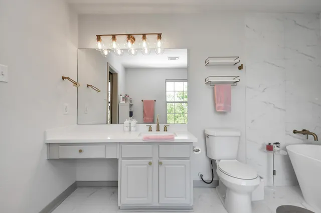a bathroom with a toilet sink and mirror