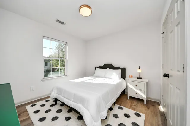 a bedroom with a bed and wooden floor