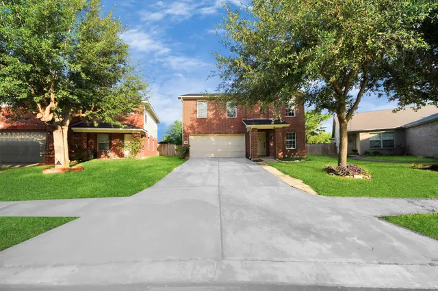 a front view of a house with a yard and trees