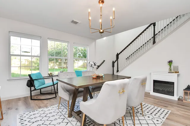 a dining room with furniture a rug a fireplace and a chandelier