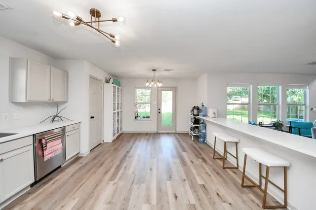 a large kitchen with cabinets wooden floor and stainless steel appliances