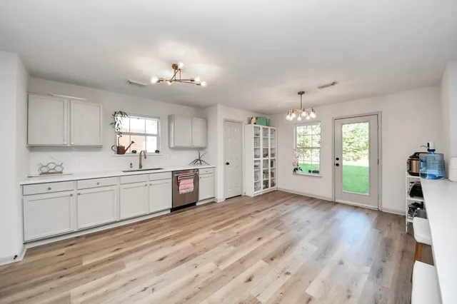 a large kitchen with kitchen island white cabinets and wooden floor
