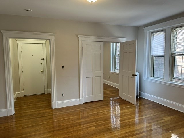 1 Craigie Street, Unit 26 Cambridge, MA 02138 - Photo 5 of 20 an empty room with wooden floor and windows