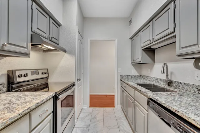 a kitchen with stainless steel appliances granite countertop a sink stove and cabinets