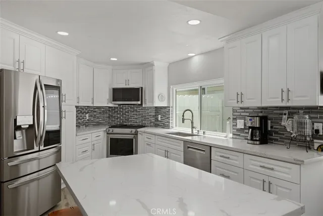 a kitchen with a sink stainless steel appliances and cabinets
