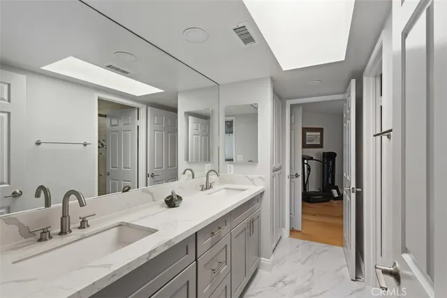 a spacious bathroom with a double vanity sink and a mirror