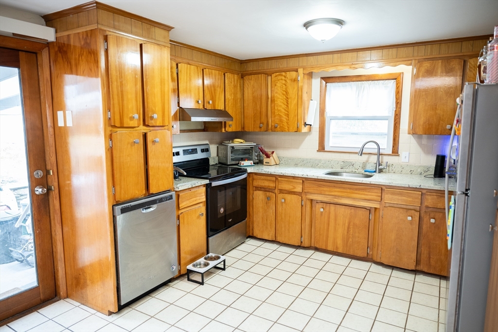 10 Chris Road Oxford, MA 01540 - Photo 14 of 42 a kitchen with stainless steel appliances granite countertop a refrigerator a sink dishwasher a stove with white cabinets and wooden floor