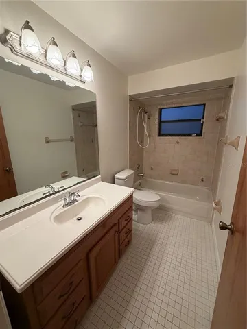 a view of an empty room with wooden floor and fan
