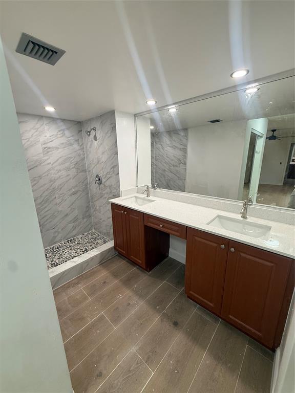 9138 Southwest 23rd Street, Unit B Davie, FL 33324 - Photo 18 of 21 a bathroom with a double vanity sink a large mirror and shower