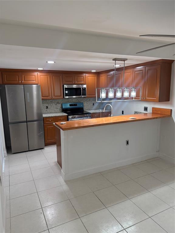 9138 Southwest 23rd Street, Unit B Davie, FL 33324 - Photo 5 of 21 a kitchen with stainless steel appliances granite countertop a sink and a refrigerator