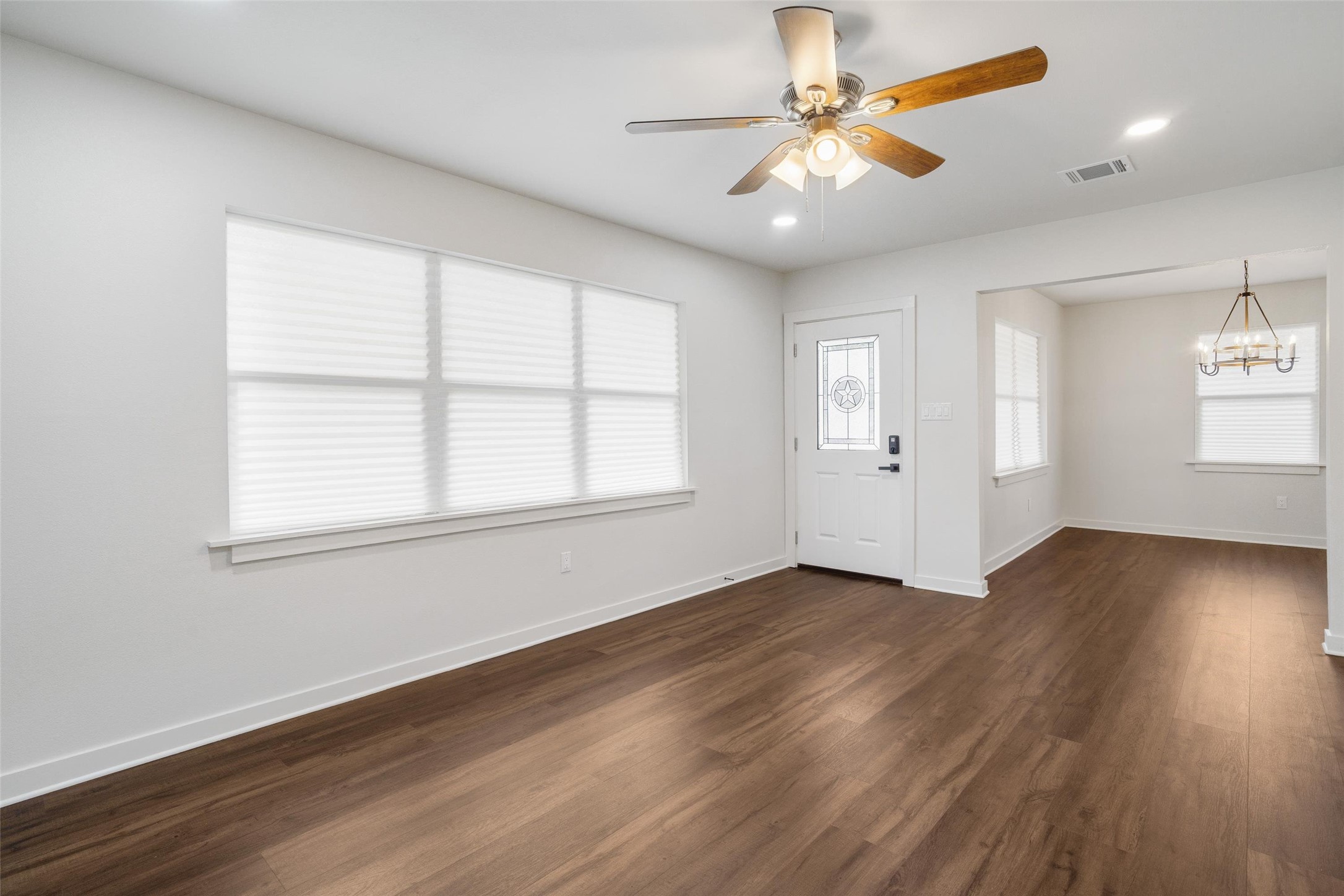 1801 Harding Street Pasadena, TX 77502 - Photo 7 of 22 an empty room with wooden floor chandelier fan and windows