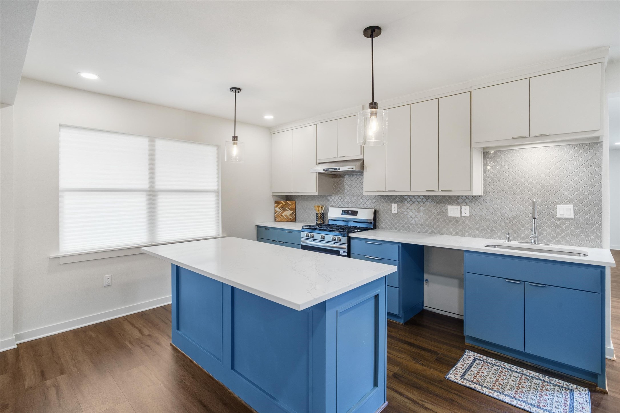 1801 Harding Street Pasadena, TX 77502 - Photo 10 of 22 a kitchen with wooden cabinets a sink a center island and a window