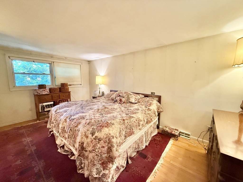 16 Meadowview Road Holyoke, MA 01040 - Photo 13 of 22 a bed sitting in a bedroom next to a window with chair and table