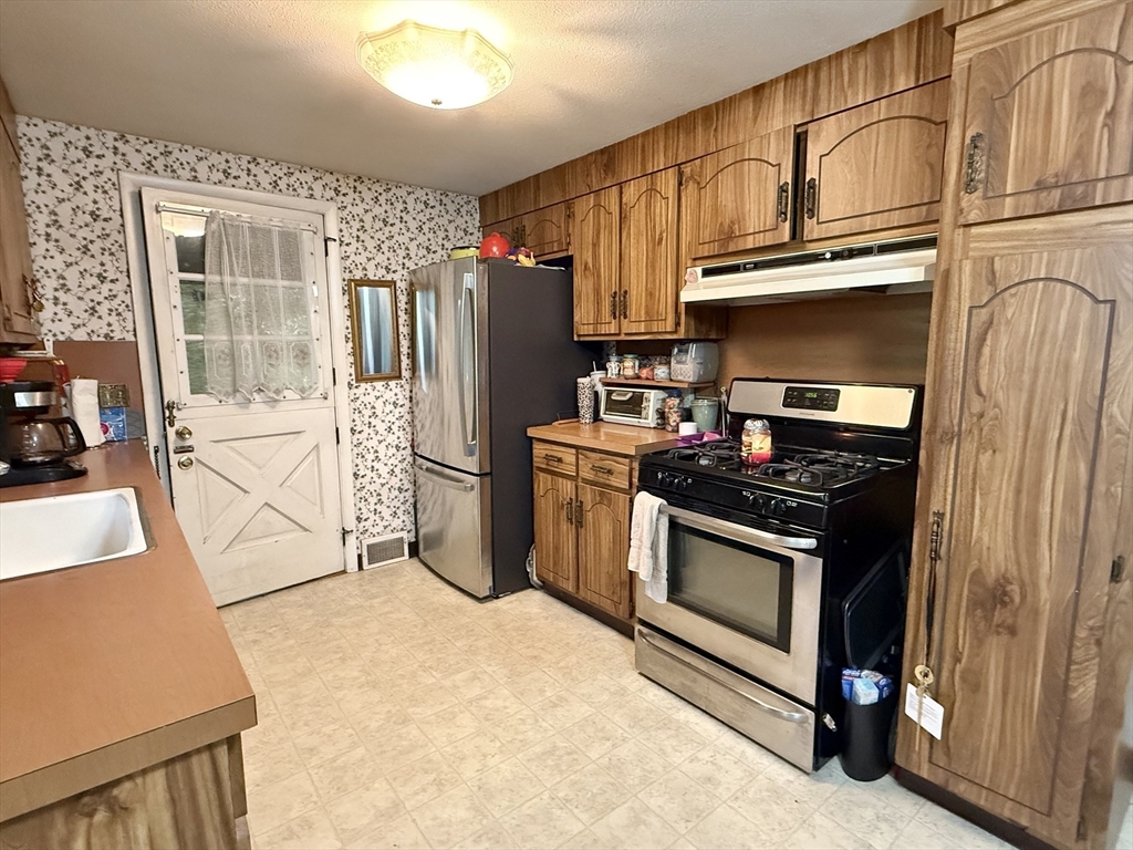 16 Meadowview Road Holyoke, MA 01040 - Photo 8 of 22 a kitchen with stainless steel appliances granite countertop a stove a refrigerator and a microwave