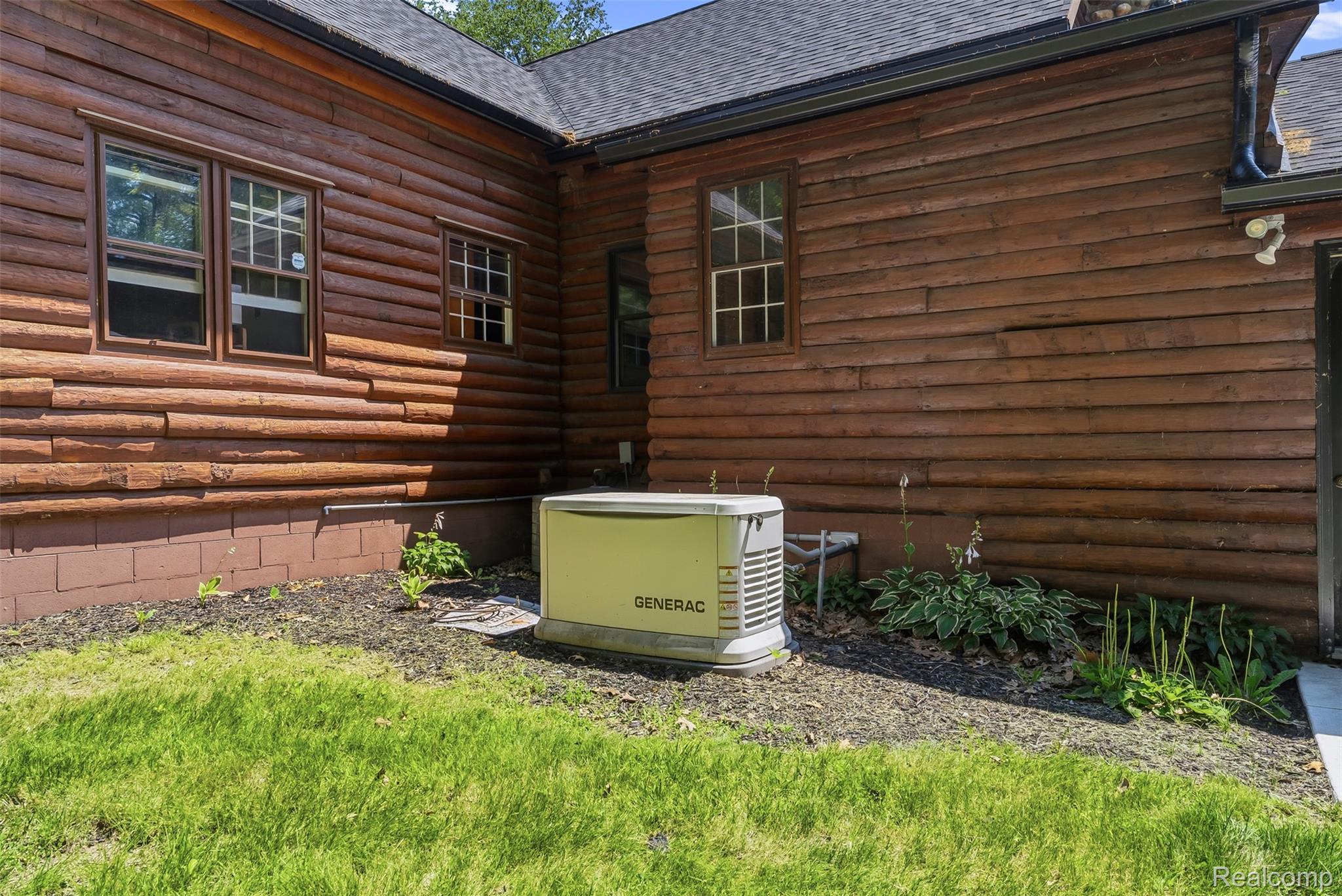 3656 Stanley Road Columbiaville, MI 48421 - Photo 46 of 65 Exterior featuring log siding, a dark roof, and a Generac whole-home generator