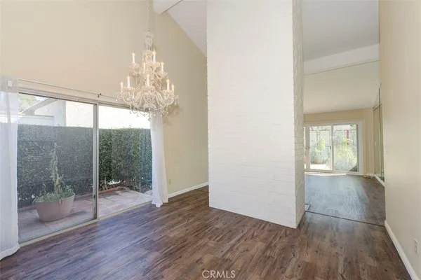 a view of a big room with wooden floor and windows