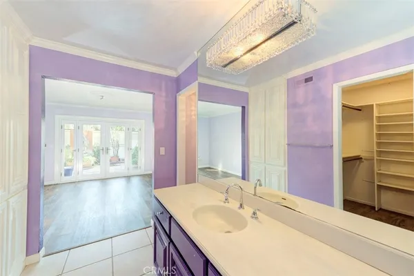 a en suite bathroom with a granite countertop sink and a mirror