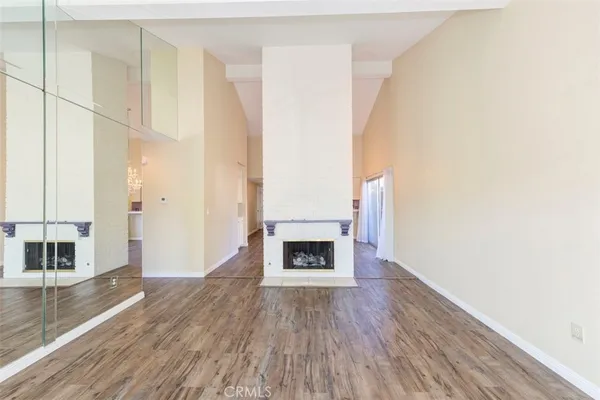 a view of a livingroom with wooden floor and a fireplace