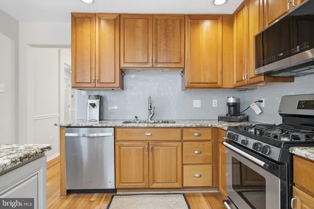 a kitchen with granite countertop wooden cabinets and a stove top oven