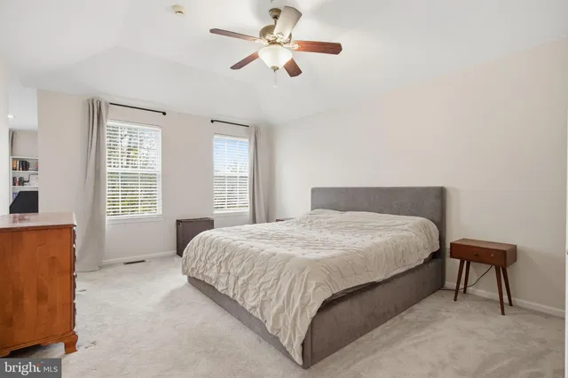 a bedroom with a bed chandelier and a window