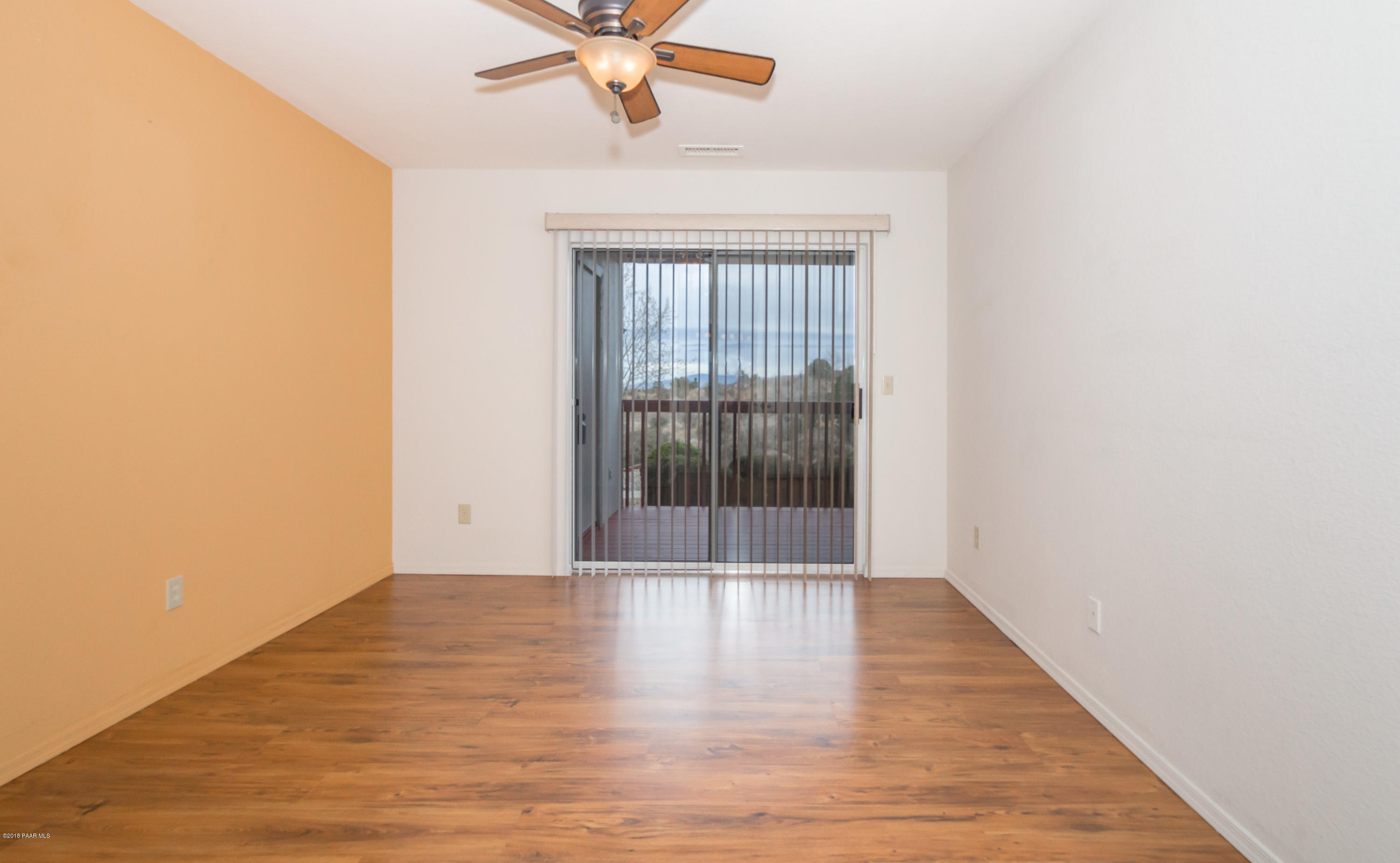 3059 Smokey Road, Unit 21B Prescott, AZ 86301 - Photo 10 of 21 a view of an empty room with wooden floor and a window
