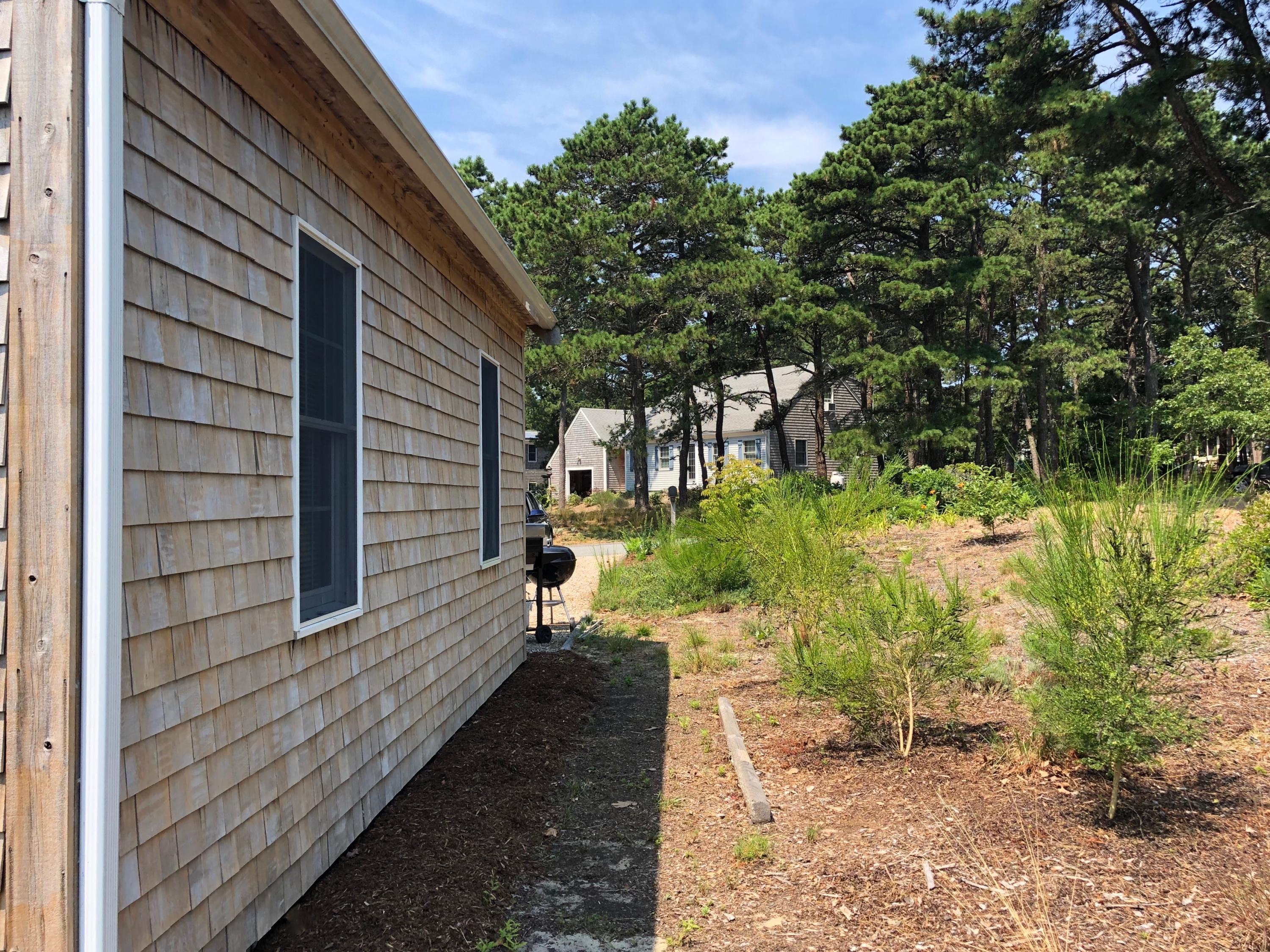 90 Jennie Clark Road Eastham, MA 02642 - Photo 28 of 35 a view of a pathway of a house with backyard and garden