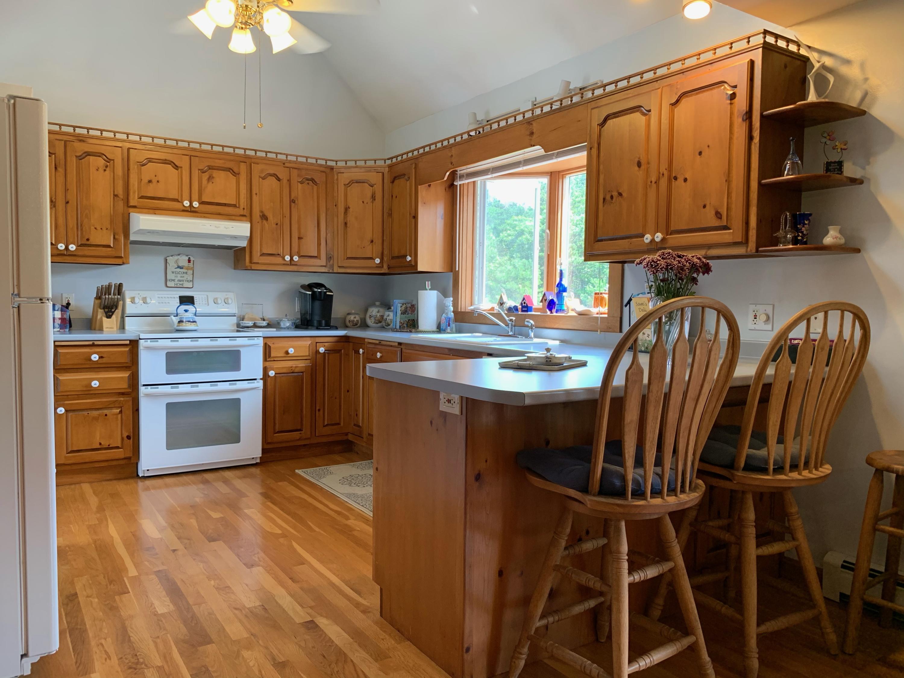 90 Jennie Clark Road Eastham, MA 02642 - Photo 5 of 35 a kitchen with stainless steel appliances granite countertop a stove a sink dishwasher and microwave oven with cabinets