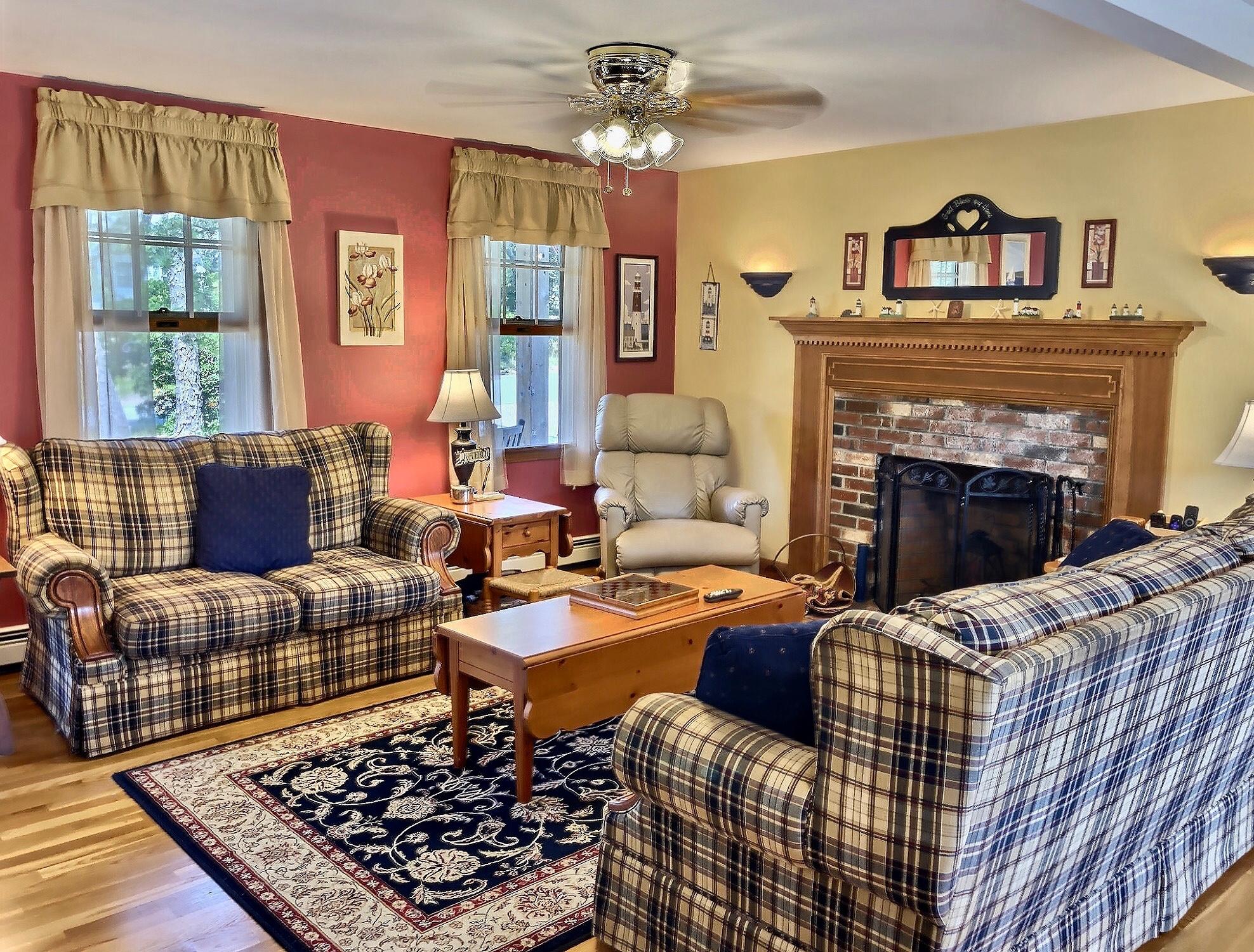 90 Jennie Clark Road Eastham, MA 02642 - Photo 6 of 35 a living room with furniture a rug and a fireplace
