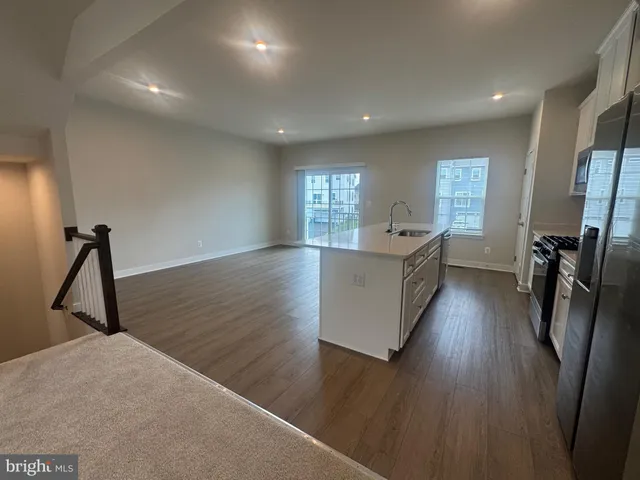 a view of a hallway with wooden floor and stairs