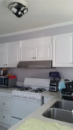 a kitchen with a sink a stove and cabinets