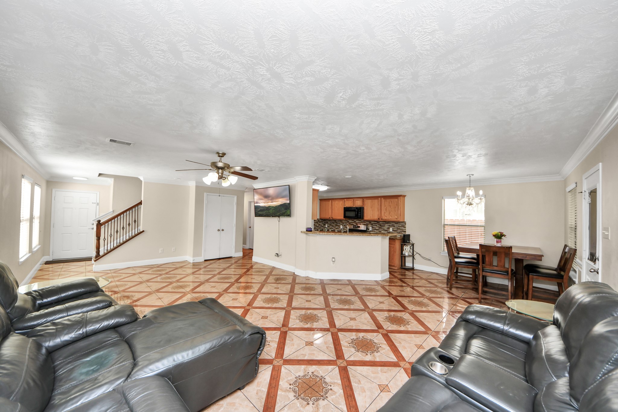 9250 Strawberry Cactus Loop Houston, TX 77064 - Photo 9 of 26 Spacious open-concept living area featuring elegant tile flooring, a cozy seating arrangement, and a modern kitchen with a stylish backsplash. Perfect for entertaining and family gatherings.