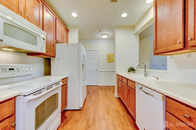 a kitchen with stainless steel appliances granite countertop a sink a stove and a wooden floors