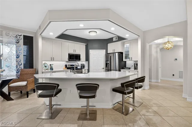 a kitchen with cabinets and chairs