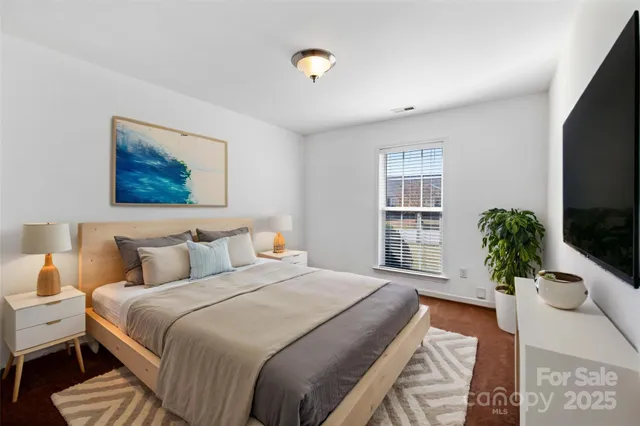 a bedroom with a bed and a potted plant