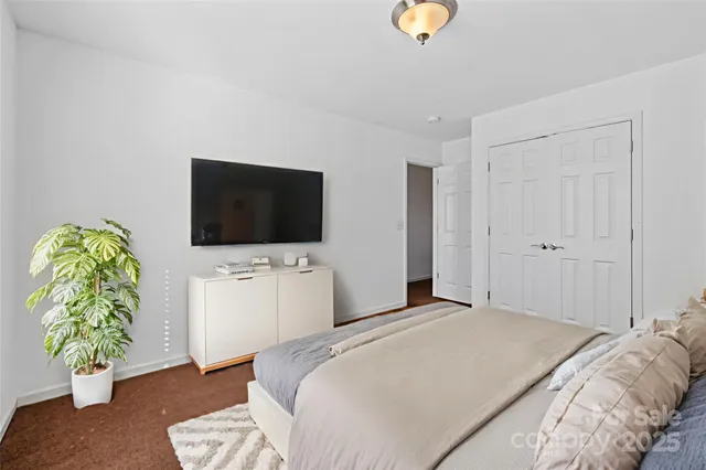 a bedroom with a bed and a flat screen tv