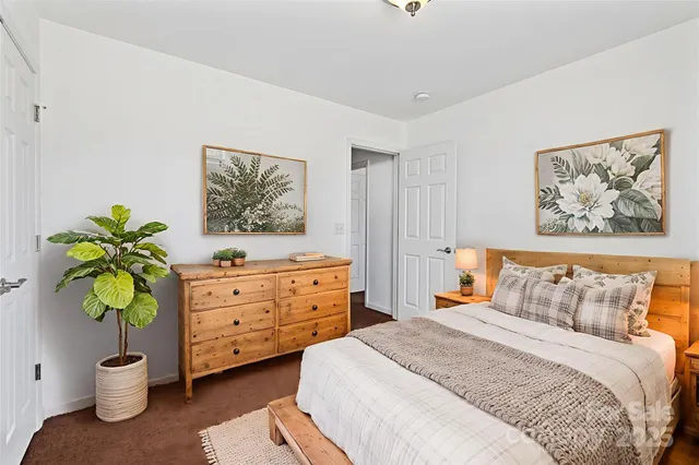 a bedroom with a bed and a painting on the wall