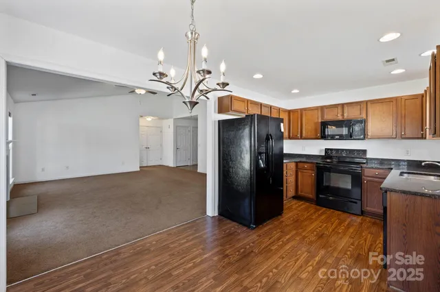 a kitchen with stainless steel appliances granite countertop a refrigerator a stove a sink and a refrigerator