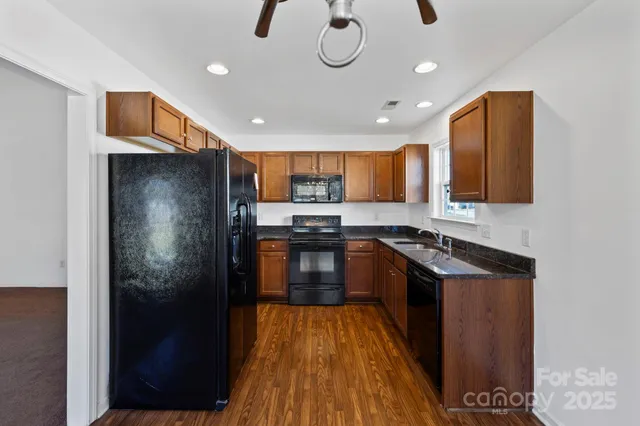 a kitchen with granite countertop stainless steel appliances and wooden cabinets
