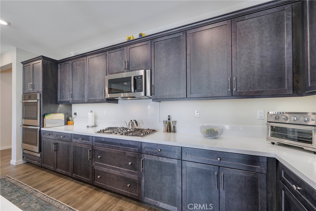79244 Zamora Court Indio, CA 92203 - Photo 11 of 52 a kitchen with stainless steel appliances granite countertop a sink a stove a microwave and wooden cabinets