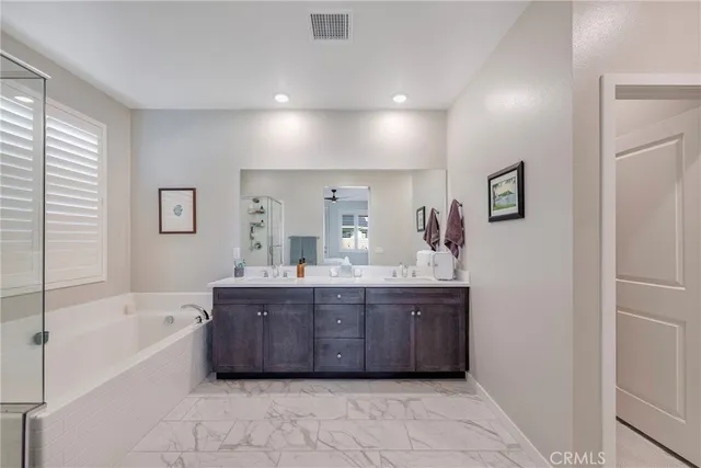 a spacious bathroom with a tub sink and mirror