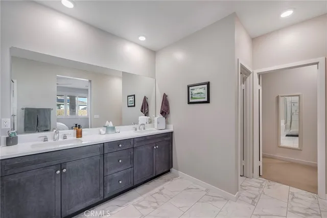 a en suite bathroom with double vanity sinks a mirror and a bath tub