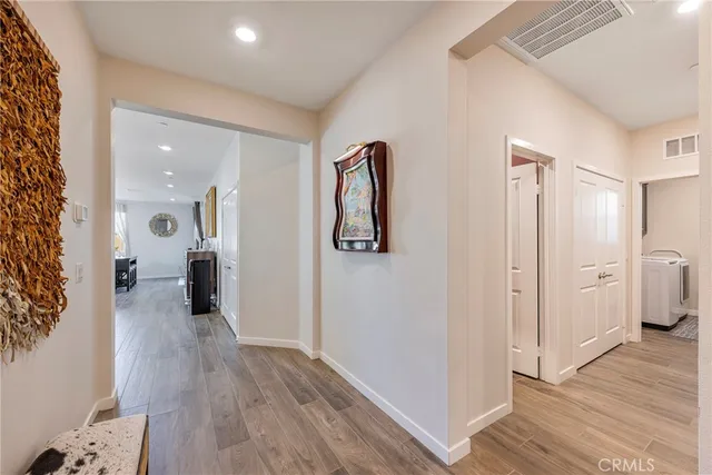 a view of a hallway with wooden floor and closet