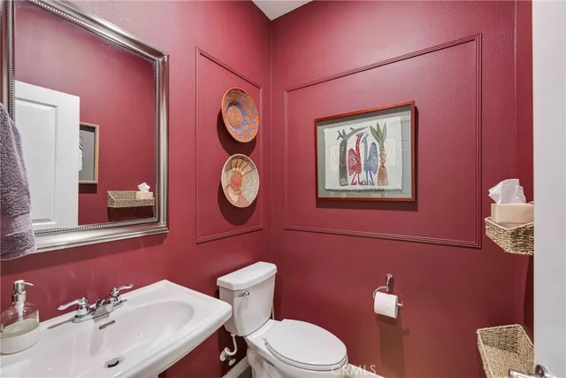 a bathroom with a toilet a sink and mirror