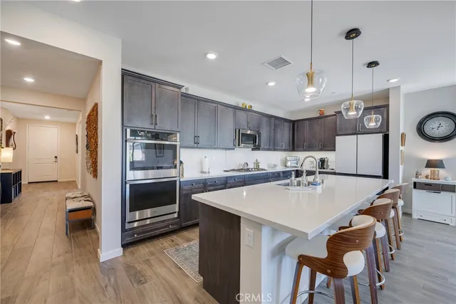 a large kitchen with cabinets wooden floor and stainless steel appliances