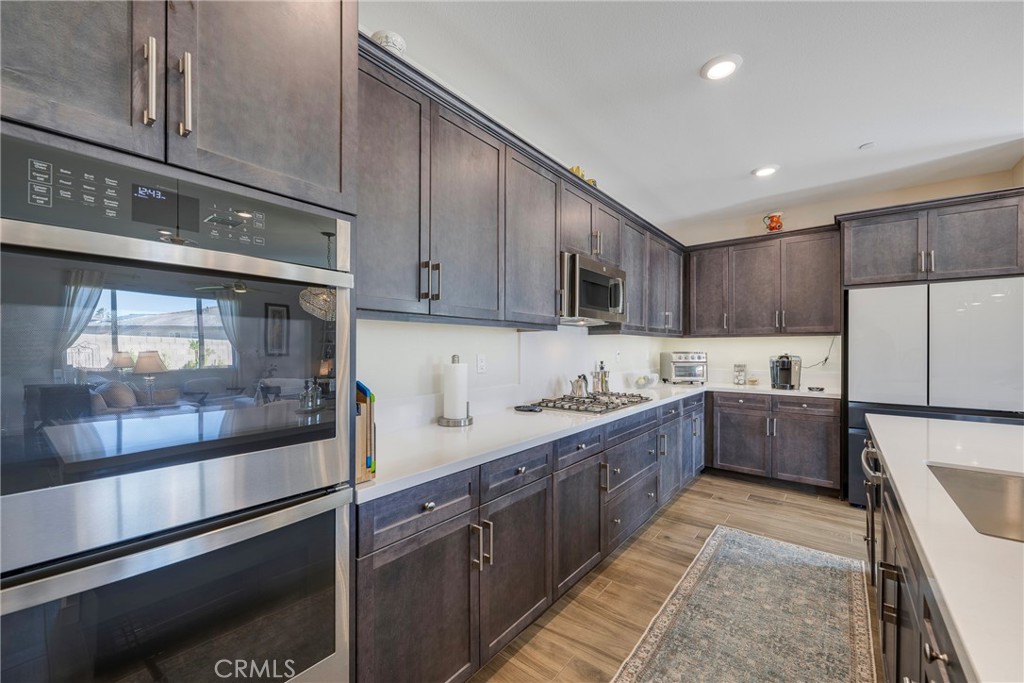 79244 Zamora Court Indio, CA 92203 - Photo 8 of 52 a large kitchen with stainless steel appliances lots of counter top space and wooden floor