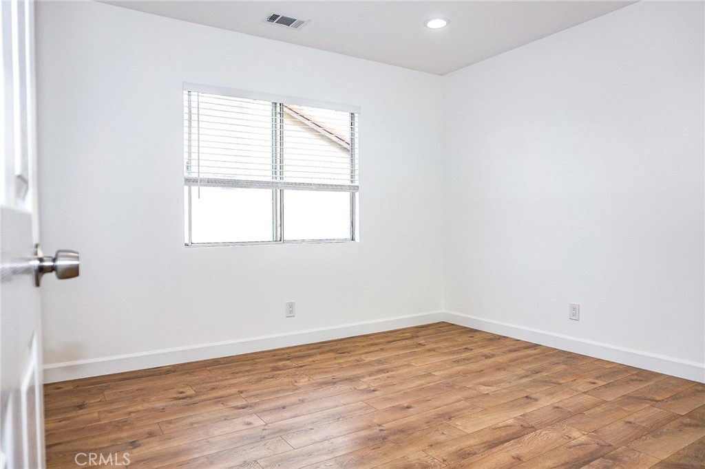 13142 Windsor Lane Garden Grove, CA 92843 - Photo 19 of 24 an empty room with wooden floor and windows