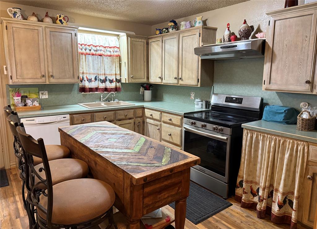555 South Allen Street Boyd, TX 76023 - Photo 7 of 14 a kitchen with stainless steel appliances granite countertop a stove a sink dishwasher and cabinets with wooden floor