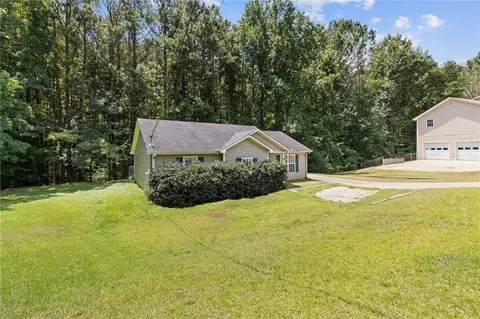 a front view of a house with yard and large trees