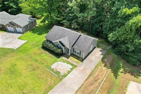 an aerial view of a house with a yard and trees