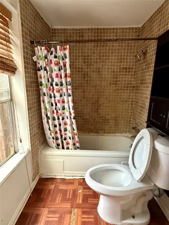 a bathroom with a toilet and a shower curtain